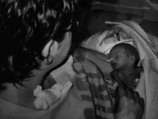 zwart wit afbeelding, moeder met prematuur geboren baby op schoot