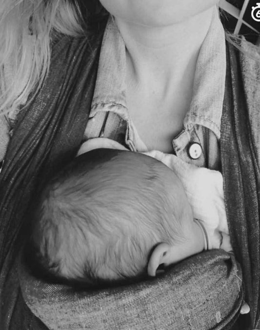 zwart wit afbeelding van moeder met baby in draagdoek